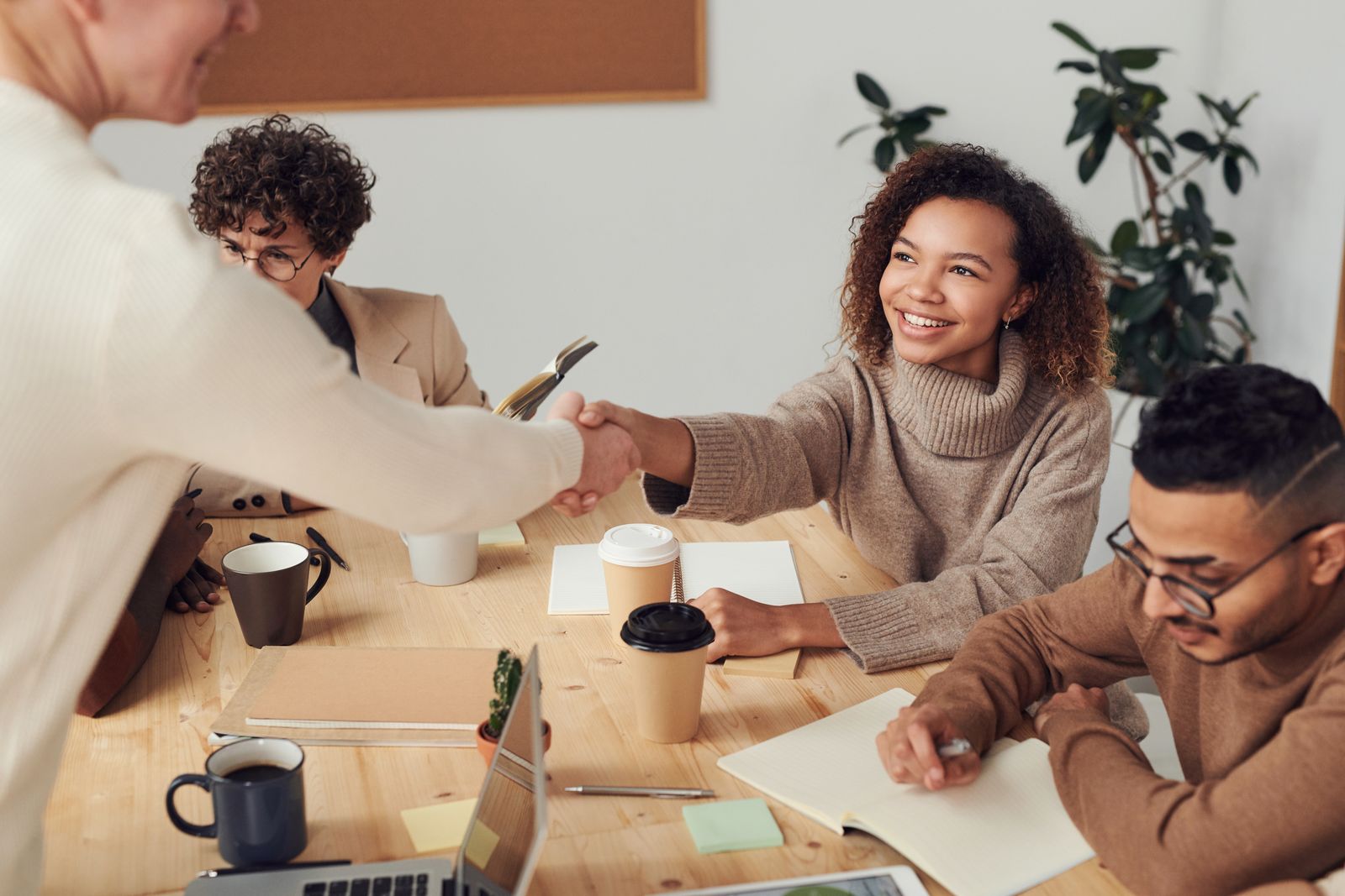 Two agency professionals shaking hands in a meeting
